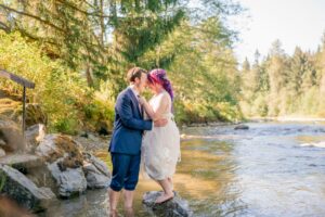 Couple standing in the Pilchuck River at River Valley Oasis