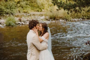 Couple embracing with river and forest in the background