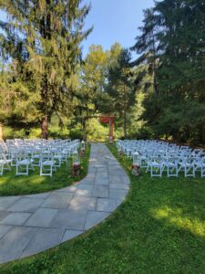 Side angle of the ceremony arch with forest backdrop