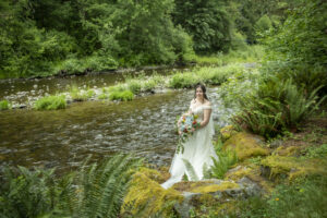 bride posing on rock steps to the river