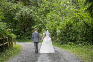 a couple strolls down the road surrounded by trees