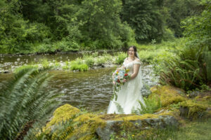 bride posing on rock steps to the river