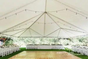 Reception tent with wood dance floor and guest tables at River Valley Oasis